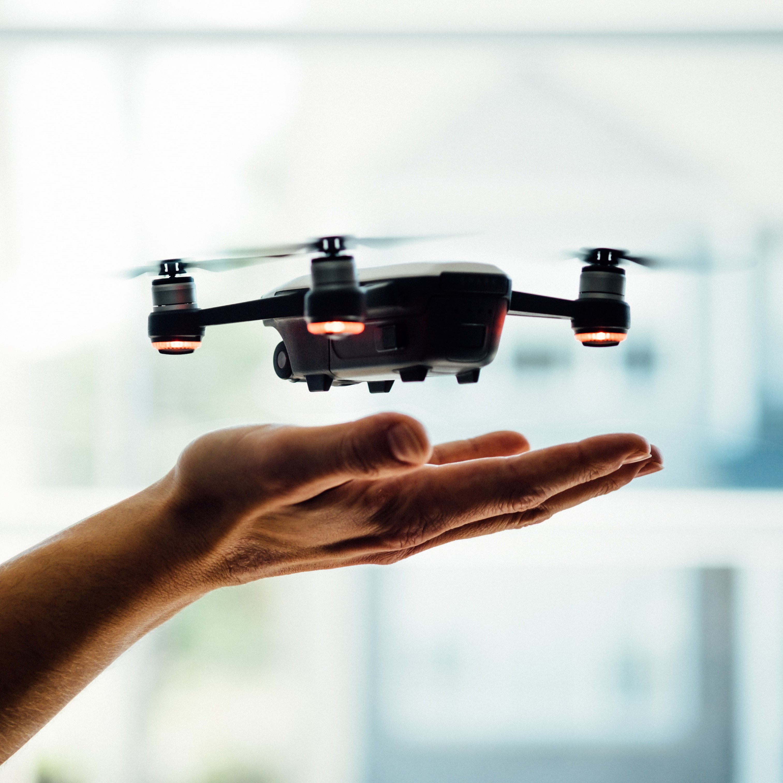 Illustration représentant une main faisant décoller un drone. 
